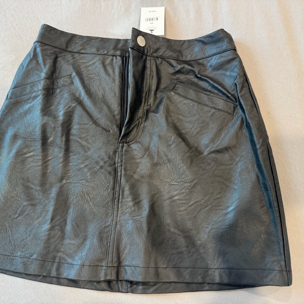 Black faux leather mini skirt with front pockets and a button closure Size XS